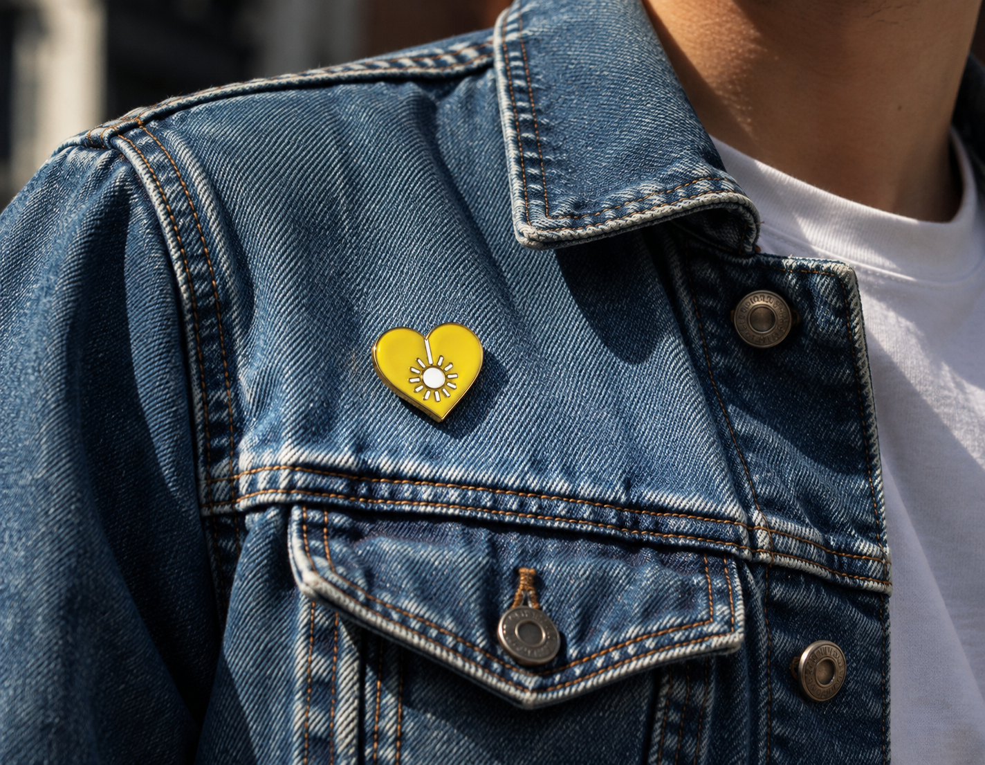 Little Sun heart pin on a denim jacket